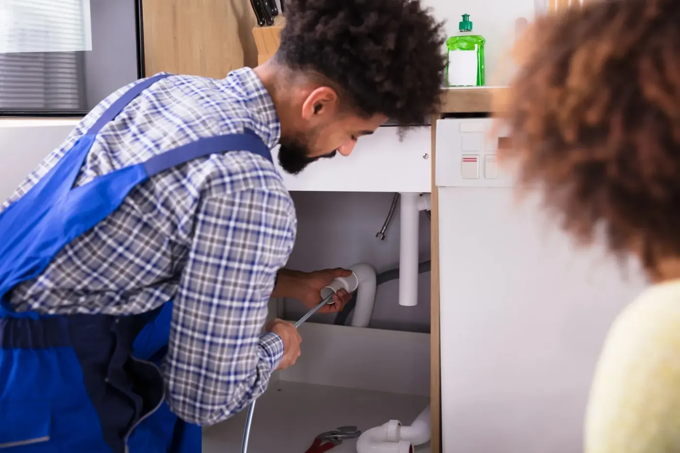 Plombier-dépanneur intervenant sur une installation sanitaire